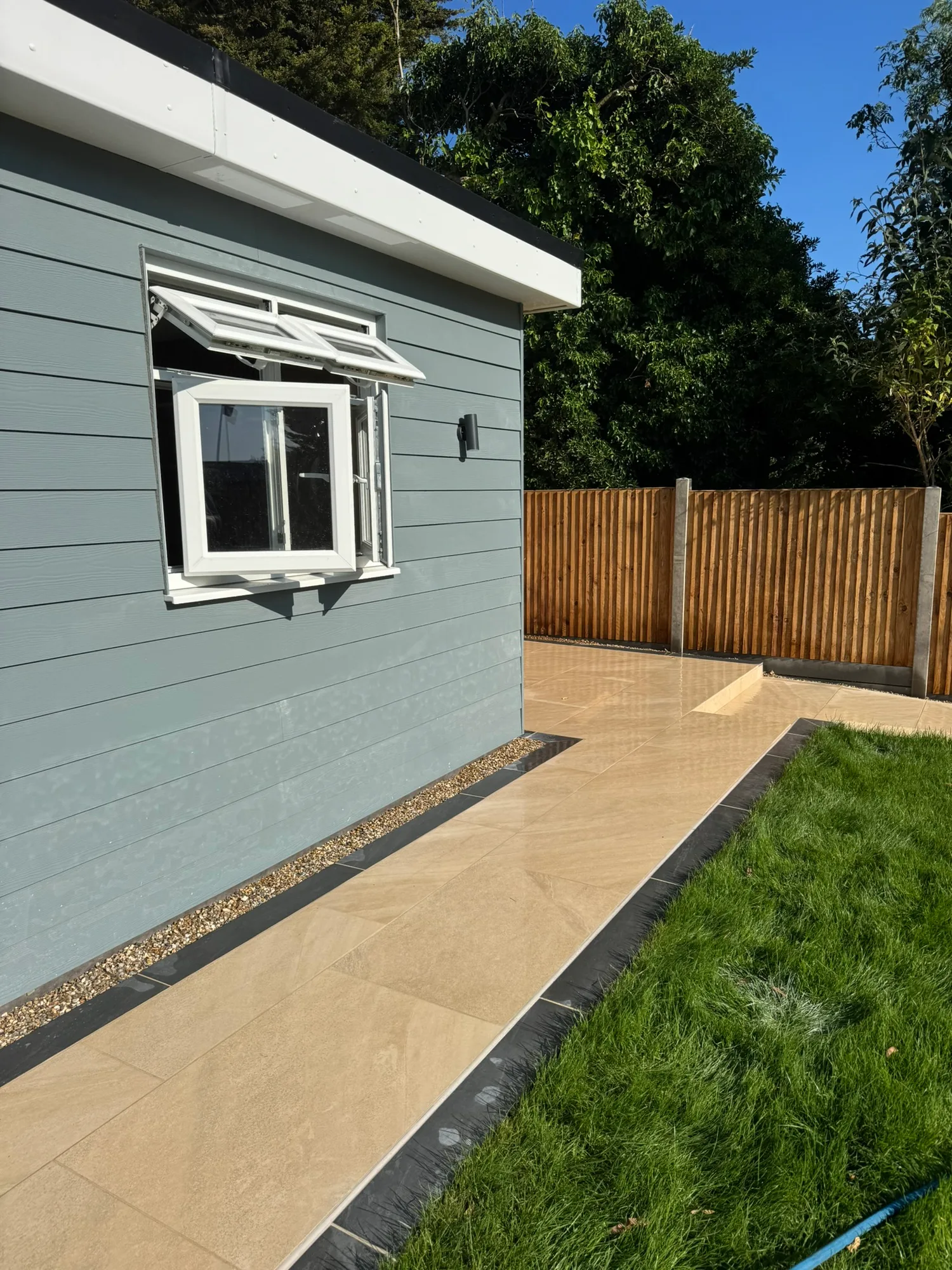 Timber-clad garden room with a porcelain path in Essex