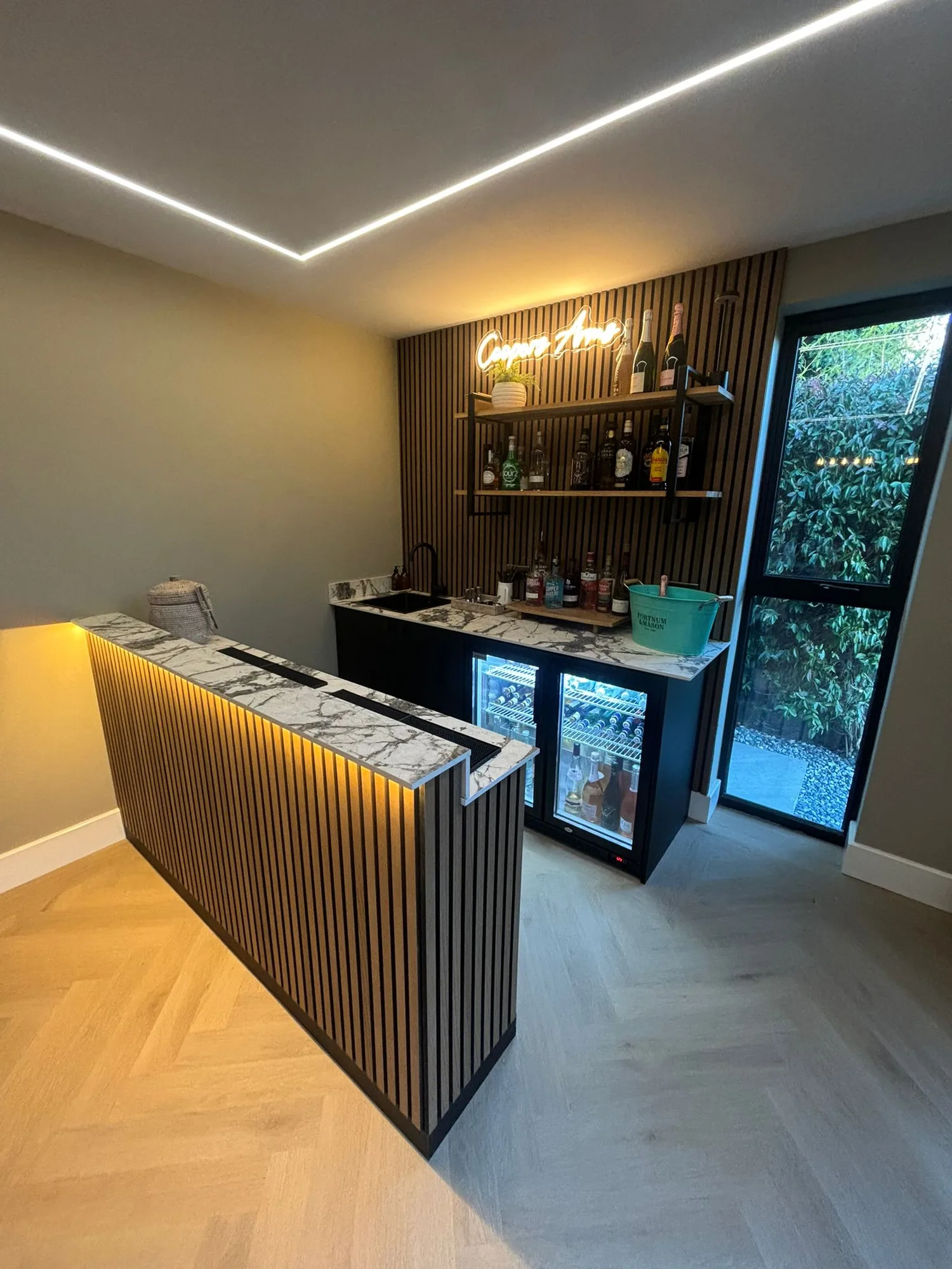Fitted bar with marble worktop inside a garden room extension in Essex