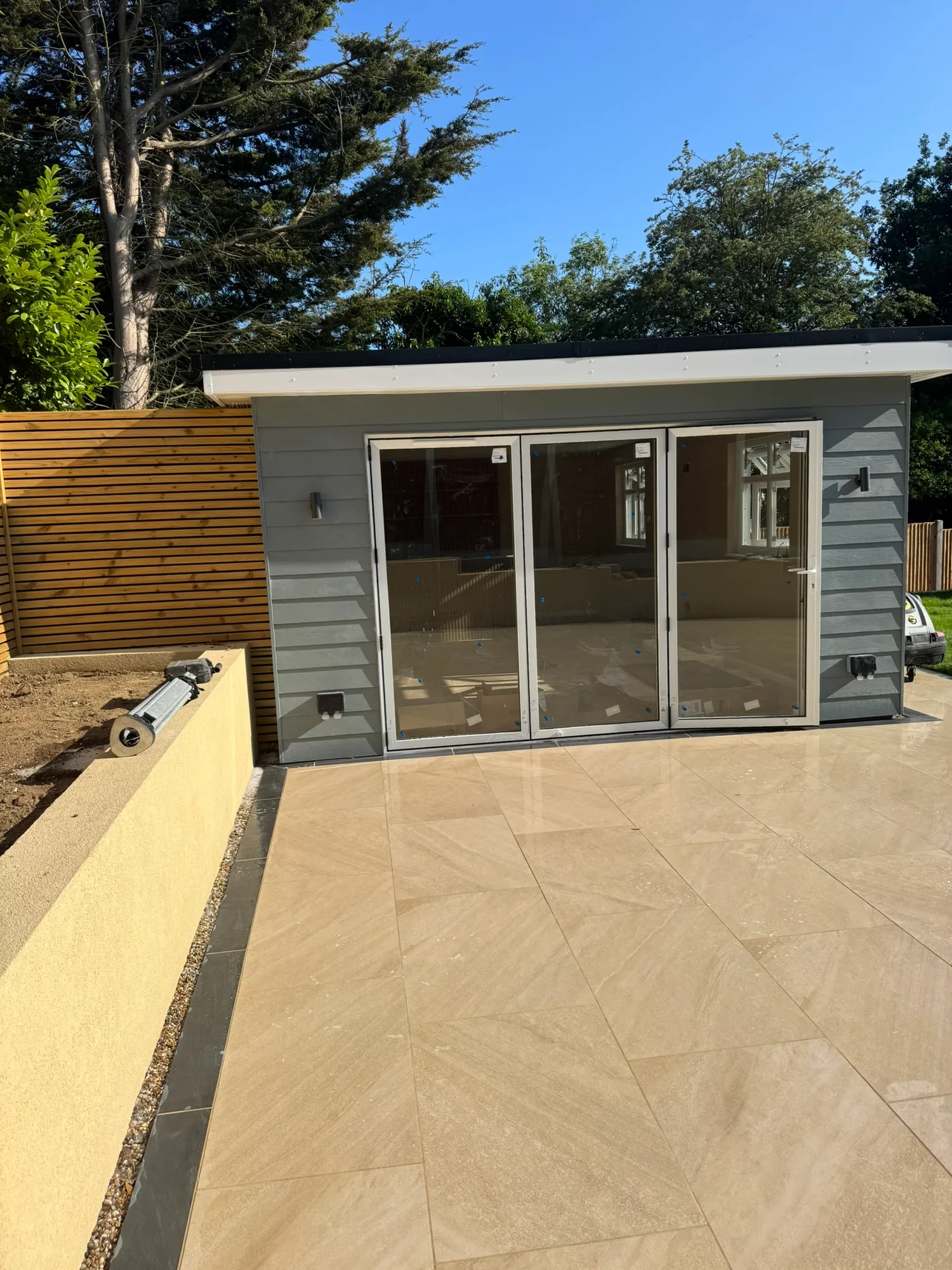 Modern garden room with grey bifold doors and porcelain patio in Essex