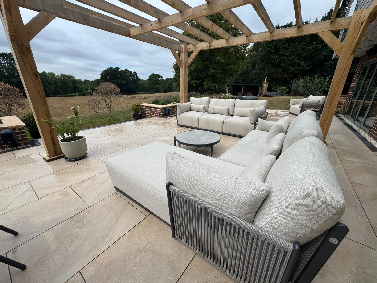 Porcelain patio under an oak pergola with countryside views, built in Essex